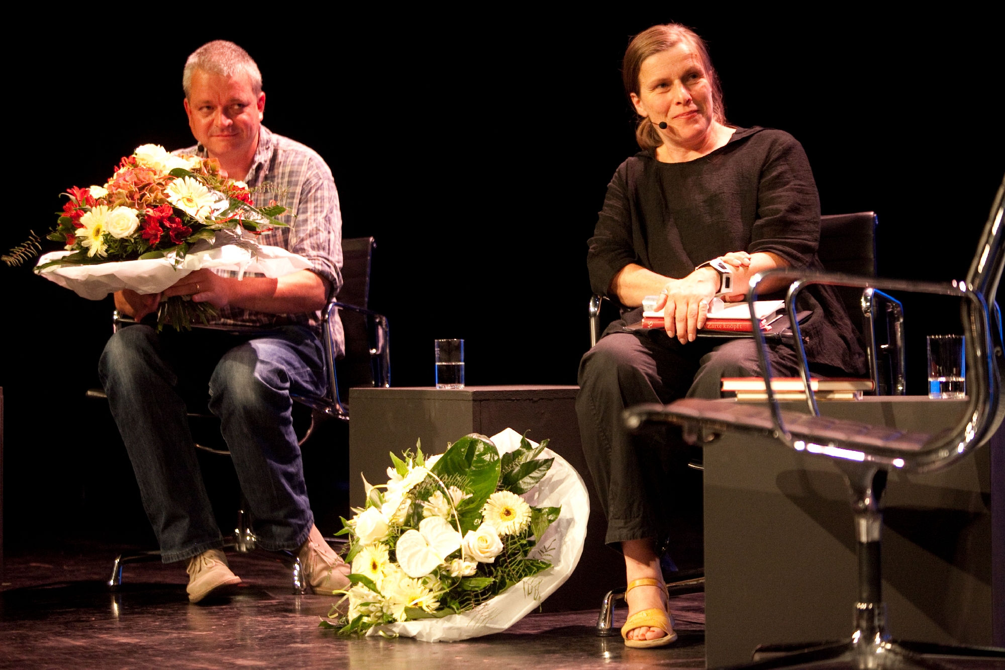 Ulf Stolterfoht und Barbara Köhler sitzen und haben einen Blumenstrauß in der Hand.