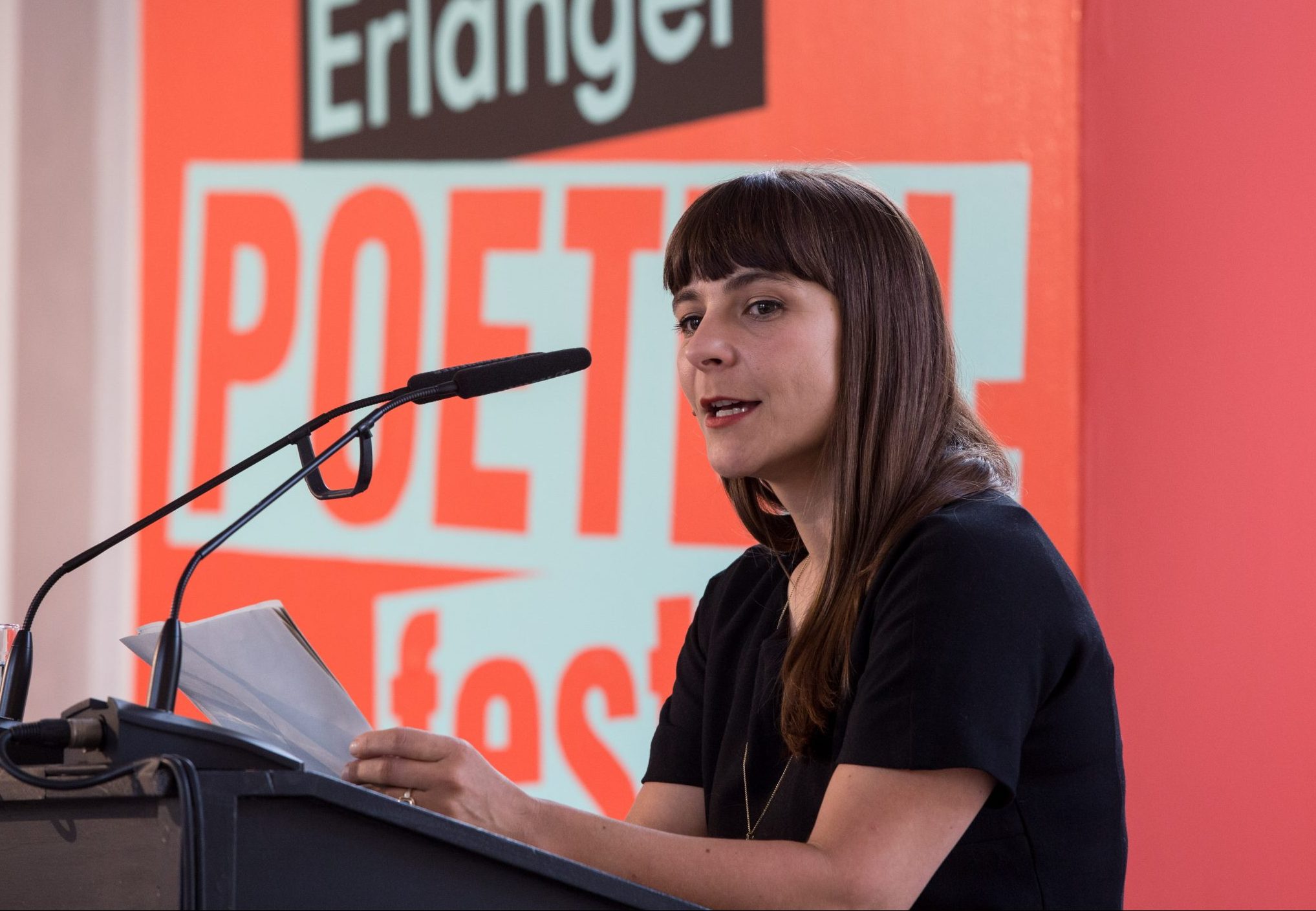 Uljana Wolf trägt ihr Laudation für Dagmara Kraus vor, im Hintergrund eine orangene Leinwand welche mit '37. Erlanger Poetenfest 2017' beschriftet ist