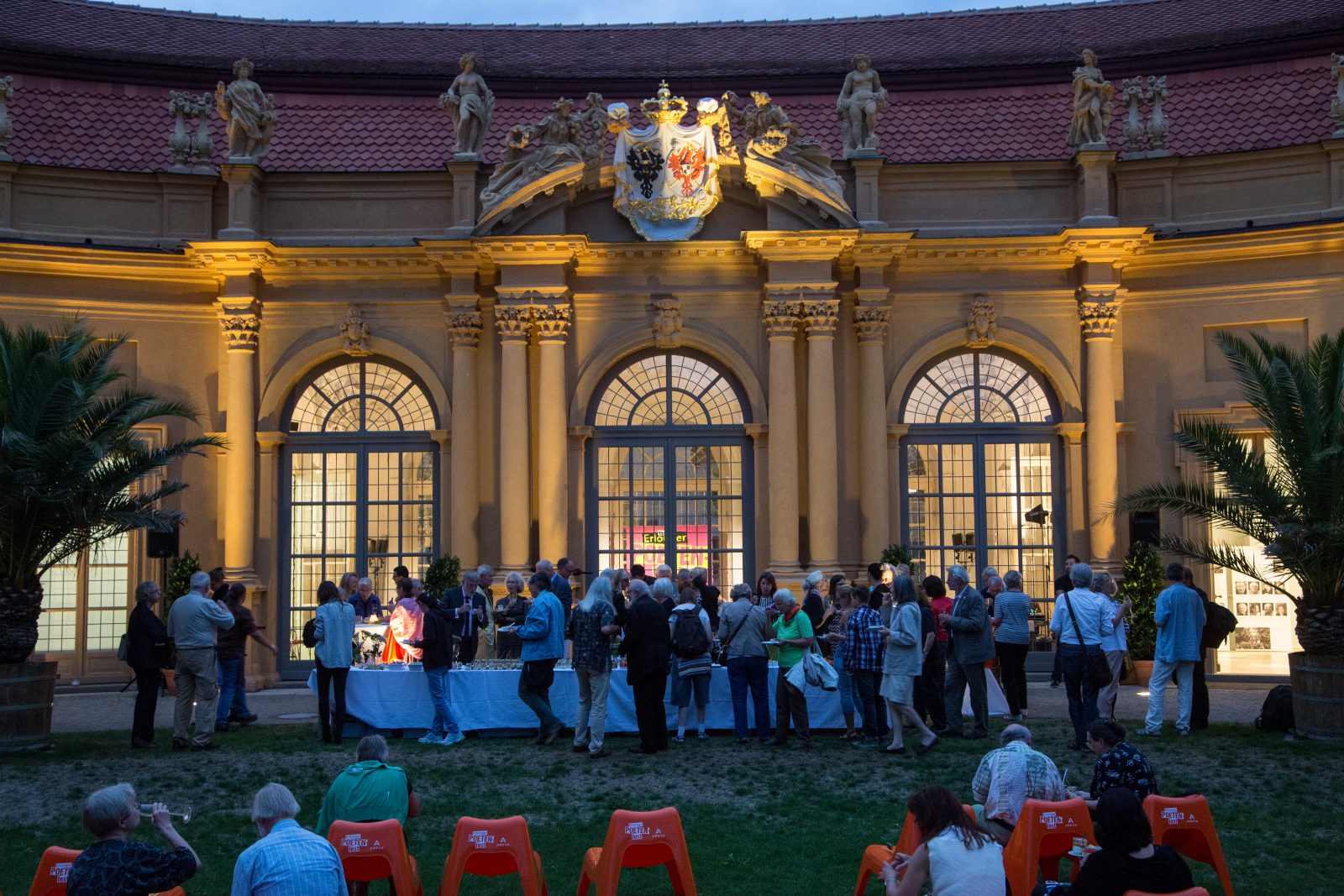 Szenen mit vielen Menschen um das Büffet vor der Orangerie
